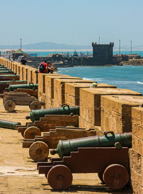 Cannons on a fortress wall facing the sea, capturing historical and coastal scenery. Essaouira Day Trip