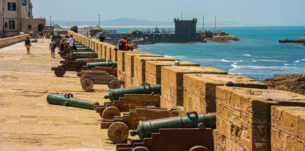 Cannons on a fortress wall facing the sea, capturing historical and coastal scenery. Essaouira Day Trip