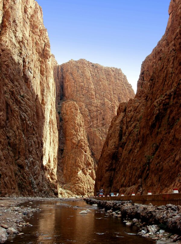 Captivating view of Todra Gorge's towering cliffs and tranquil stream in Tinghir, Morocco.