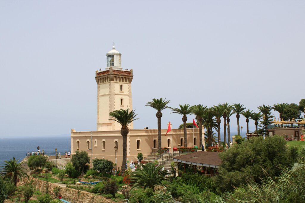 Explore the stunning Cape Spartel Lighthouse near Tangier, Morocco, surrounded by lush palm trees and ocean views.